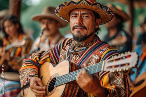 A musician in a sombrero is performing folk music on a guitar for a crowd