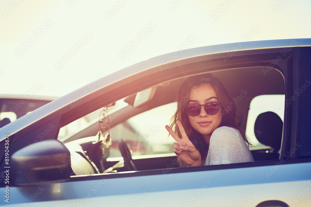 Naklejka premium Woman, car and sunglasses by window in summer for travel, freedom and vacation with sunshine outdoor. Girl, shades and relax with peace sign in motor for road trip, holiday or adventure in California
