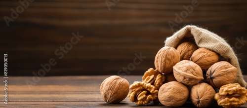 Walnuts in a burlap bag with copy space on a wooden background