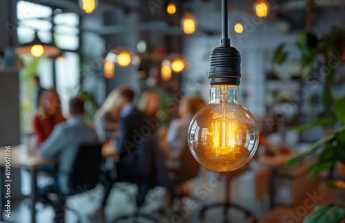 Group of People Sitting Around Table With Light Bulb in Background