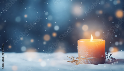 A candle is lit on a snowy ground