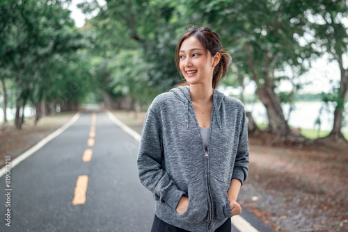 Asian woman in hoodie running sport exercises outdoors on a background of park trees on springtime. Healthy lifestyle well being wellness happiness concept © oatawa