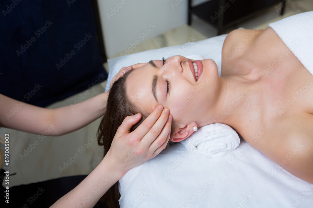 Beautiful young woman getting facial massage in spa salon. Beauty treatment concept. Beautiful young woman getting facial massage in spa salon. Beauty treatment concept.