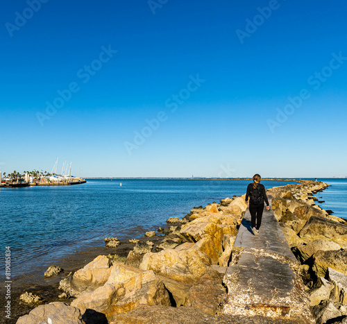 Female Tourist Walking on Seawall Extending Across Corpus Christi Bay, Corpus Christi, Texas, USA