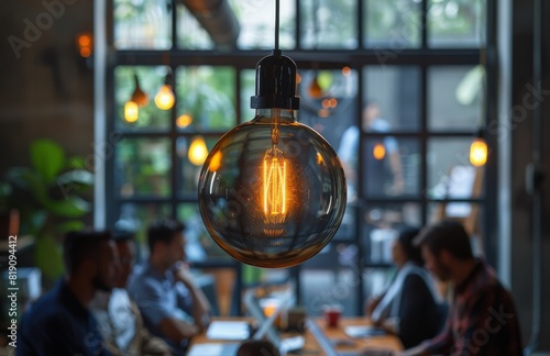 Group of People Sitting at Table Under Hanging Light Bulb