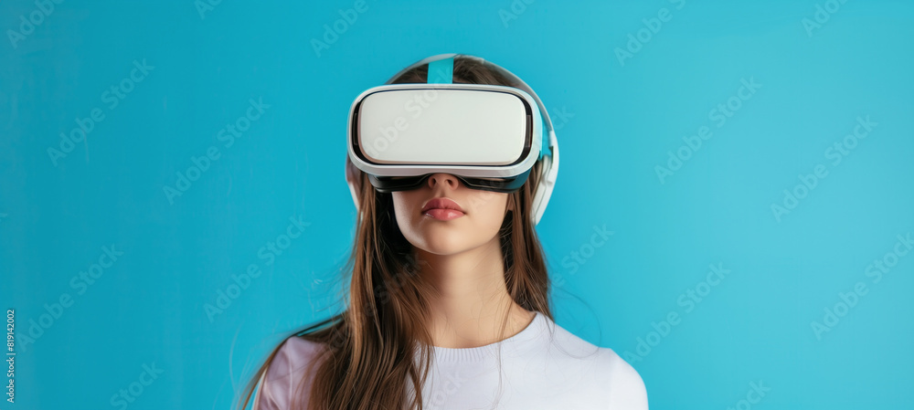 Young girl getting experience using VR headset glasses isolated on a blue background Young girl getting experience using VR headset glasses isolated on a blue background