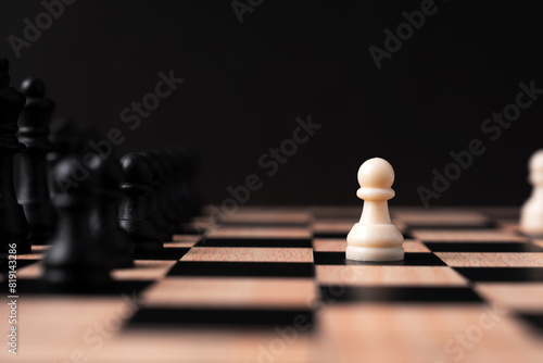 White pawn chess face off with black chess set black background
