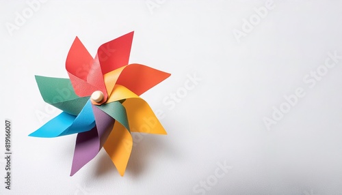 pinwheel or windmill paper origami isolated on white background simple starter craft for kids for weekend entertainment. ESG and Clean Energy Concept. Wind Turbine Paper into the Sky. Decrease Carbon