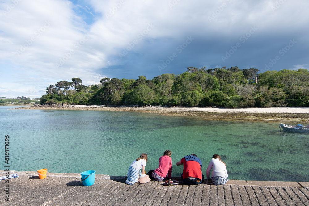 Des enfants qui pêchent des crabes avec leur père en Bretagne Des enfants qui pêchent des crabes avec leur père en Bretagne