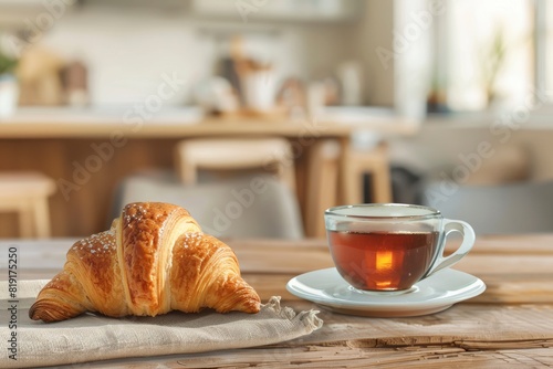 Croissant and coffee on kitchen countertop, against blurred minimalist interior with modern furniture. Selective focus at homemade pastry and tea drink in cup on wooden table - Generative Ai