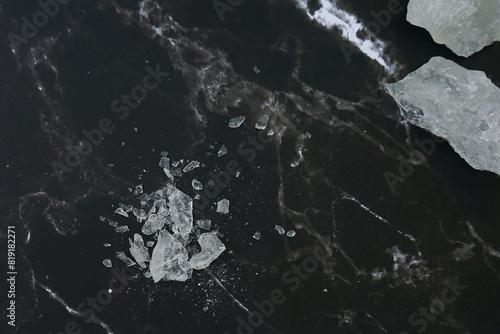 Lumps of alum on a black background. It is a mineral with clear, white crystals, odorless, astringent taste, ground into a white powder that resembles rock sugar. photo