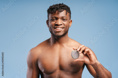 Happy smiling young African American man holding cardiac pacemaker, ICD looking at camera photo