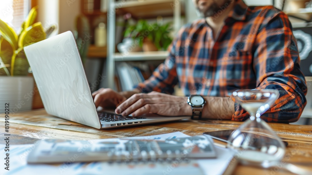 Professional businessman working remotely from home with hourglass deadline on the table Professional businessman working remotely from home with hourglass deadline on the table