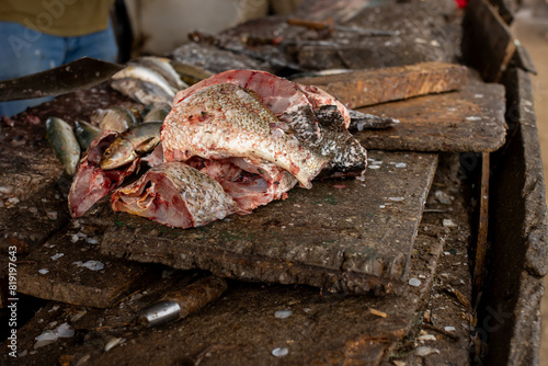 A pile of fish on a wooden cutting board at the Tanji fish market in The Gambia