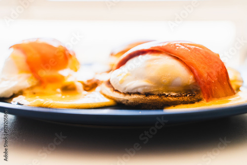 Eggs Benedict on a toasted salmon bun on a plate