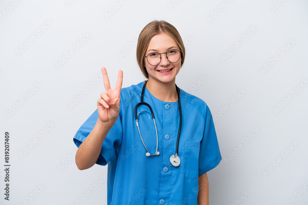 Young nurse doctor woman isolated on white background smiling and showing victory sign Young nurse doctor woman isolated on white background smiling and showing victory sign