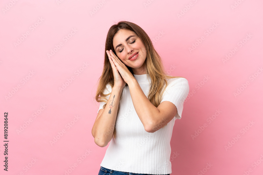 Caucasian woman isolated on pink background making sleep gesture in dorable expression Caucasian woman isolated on pink background making sleep gesture in dorable expression