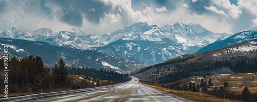 empty highway into beautiful snow capped rocky mountains. photo