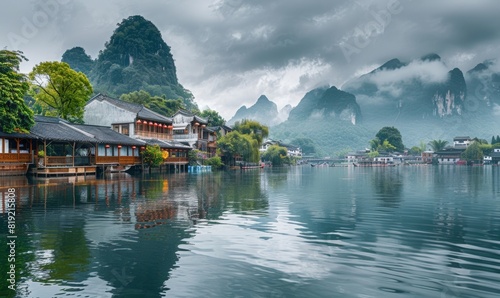 water village with house above the river. lotus plants on the water surface. beautiful cliffs in the background.