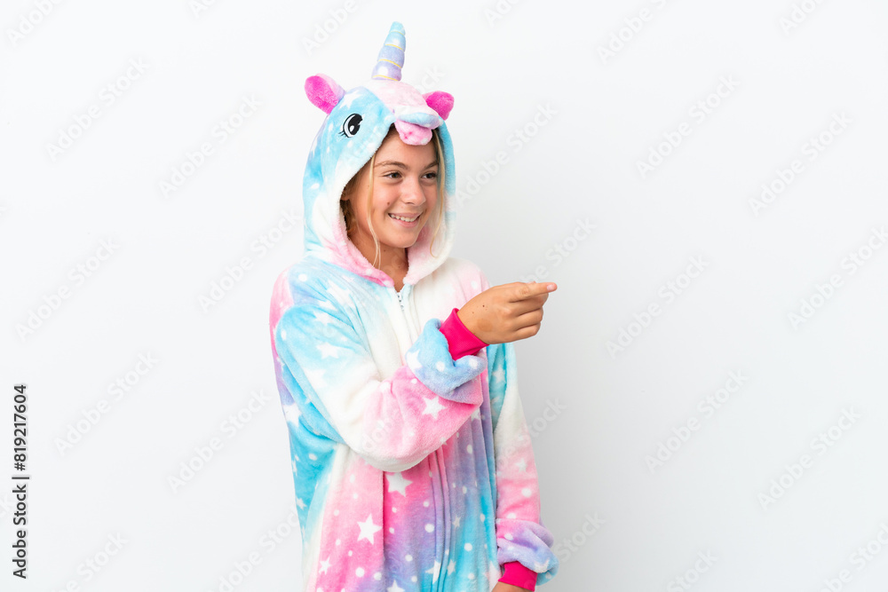 Little girl with unicorn pajamas isolated on white background pointing finger to the side and presenting a product Little girl with unicorn pajamas isolated on white background pointing finger to the side and presenting a product