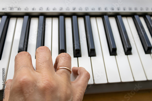 Woman's right hand above synthesizer keyboard