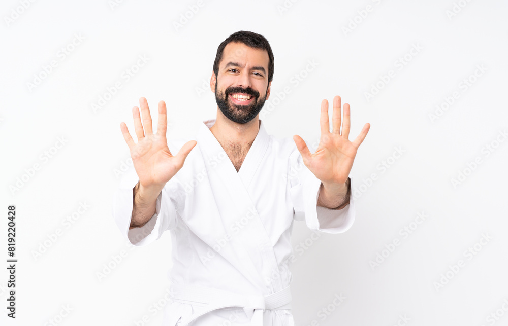 Naklejka premium Young man doing karate over isolated white background counting ten with fingers