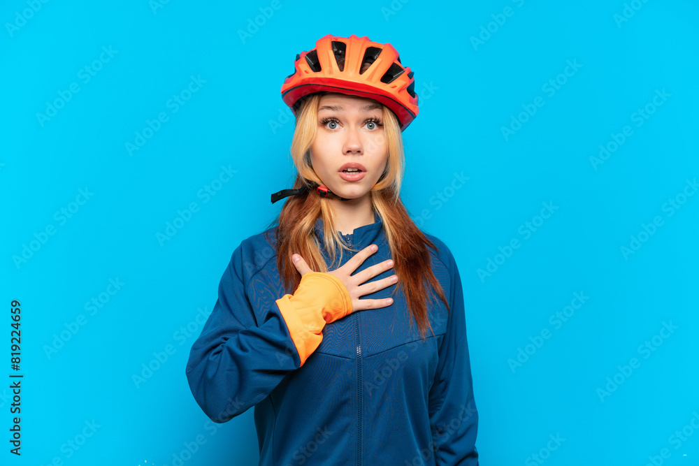 Young cyclist girl isolated on blue background surprised and shocked while looking right Young cyclist girl isolated on blue background surprised and shocked while looking right