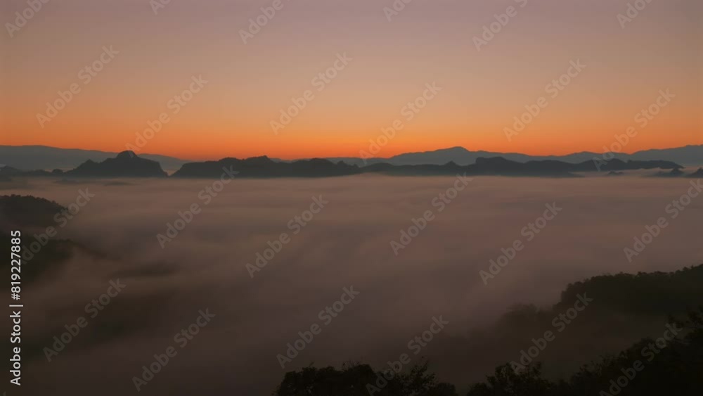 Serene landscape view of mountain range at sunrise with dense fog covering valley and silhouettes of distant peaks visible. Calm atmosphere perfect for nature, travel, and tranquility themes. Serene landscape view of mountain range at sunrise with dense fog covering valley and silhouettes of distant peaks visible. Calm atmosphere perfect for nature, travel, and tranquility themes.