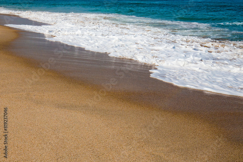 Detalhe de praia com areia e aguas não poluentes em boa condições para  banhos e utilização.