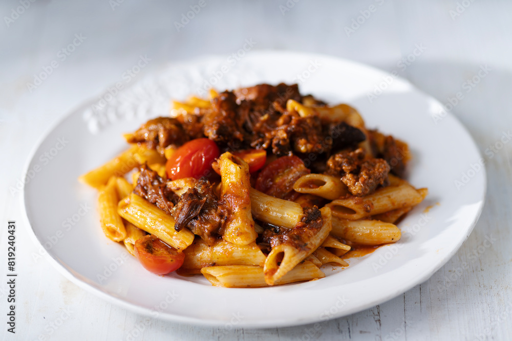 italian penne pasta in oxtail bolognese sauce