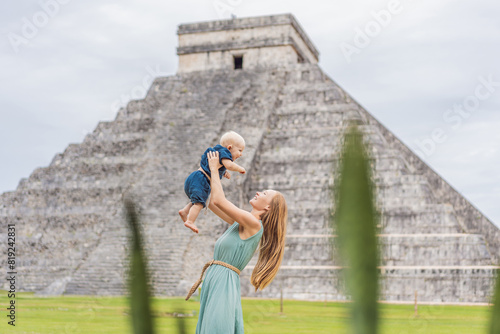 Beautiful tourist woman and her son baby observing the old pyramid and temple of the castle of the Mayan architecture known as Chichen Itza these are the ruins of this ancient pre-columbian