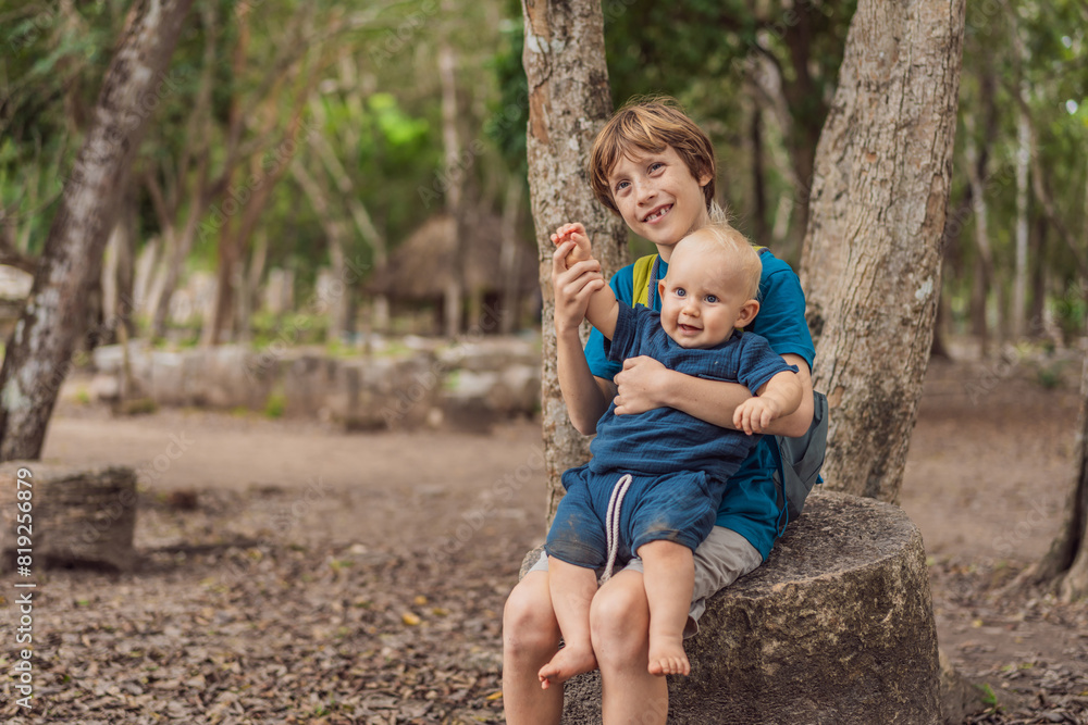 Fototapeta premium Happy laughing teen boy holding his baby brother