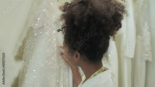 The tailor is arranging the wedding dress.. Young Asian couple enjoy preparatation for marriage caremony in fitting room at the bridal store. photo