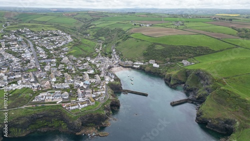 Port Isaac is a small fishing village on the Atlantic coast of north Cornwall, England, in the United Kingdom. The nearest towns are Wadebridge and Camelford, each ten miles away. A nearby hamlet, Por photo