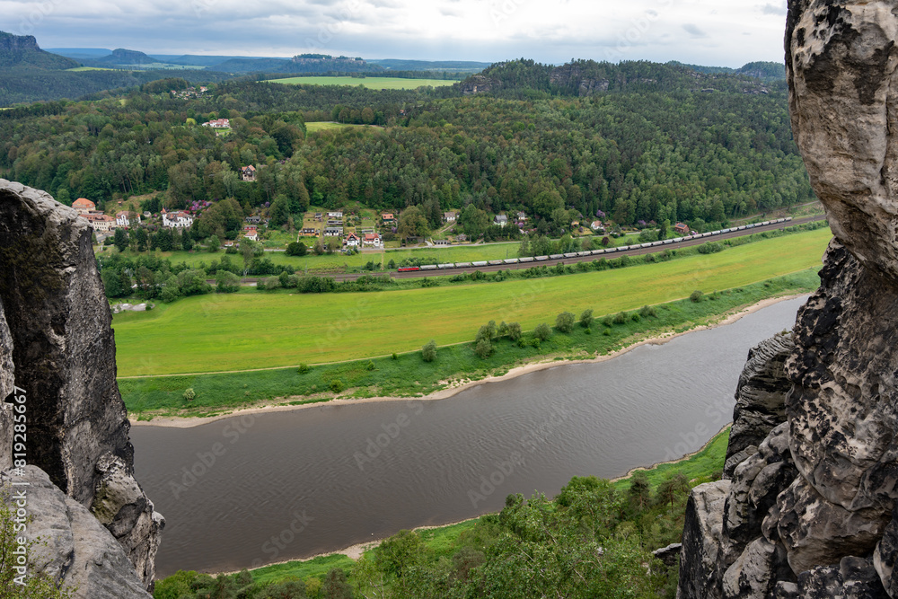 Obraz premium A river with a train passing by. The train is long and has many cars