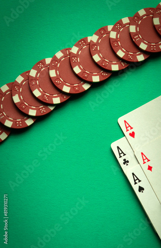 An interesting poker game with a winning combination of four of a kind or quads. Playing cards and red chips on a green table in a poker club
