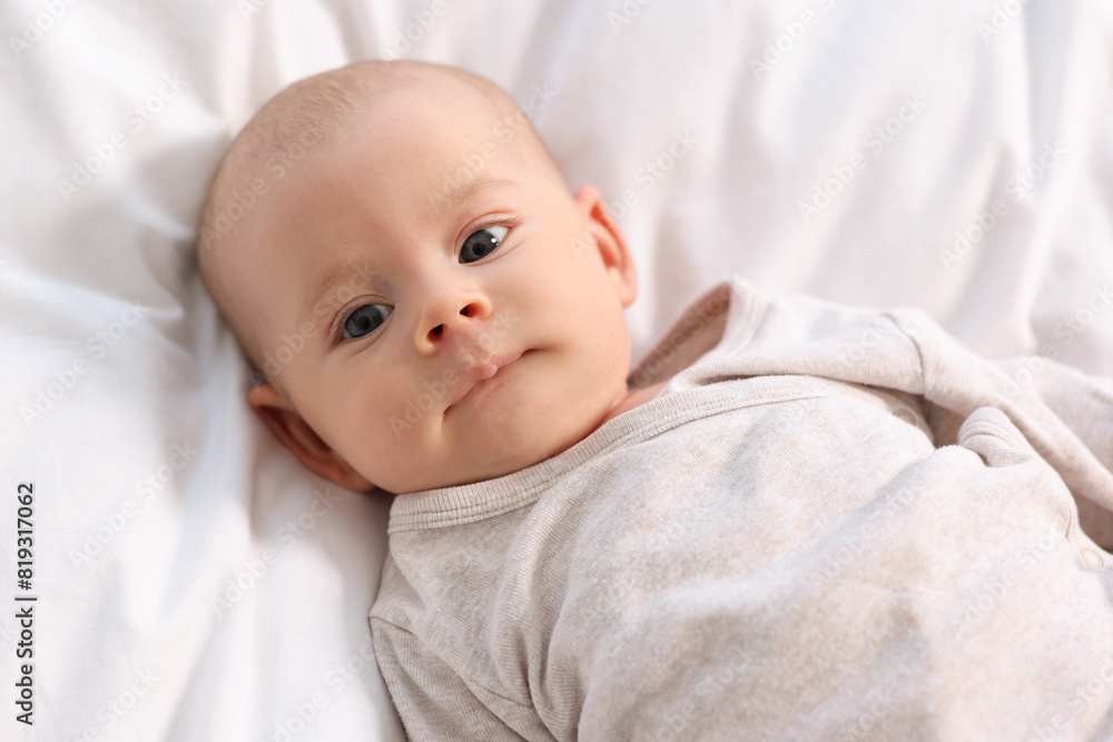 Cute little baby lying on white sheets, top view Cute little baby lying on white sheets, top view