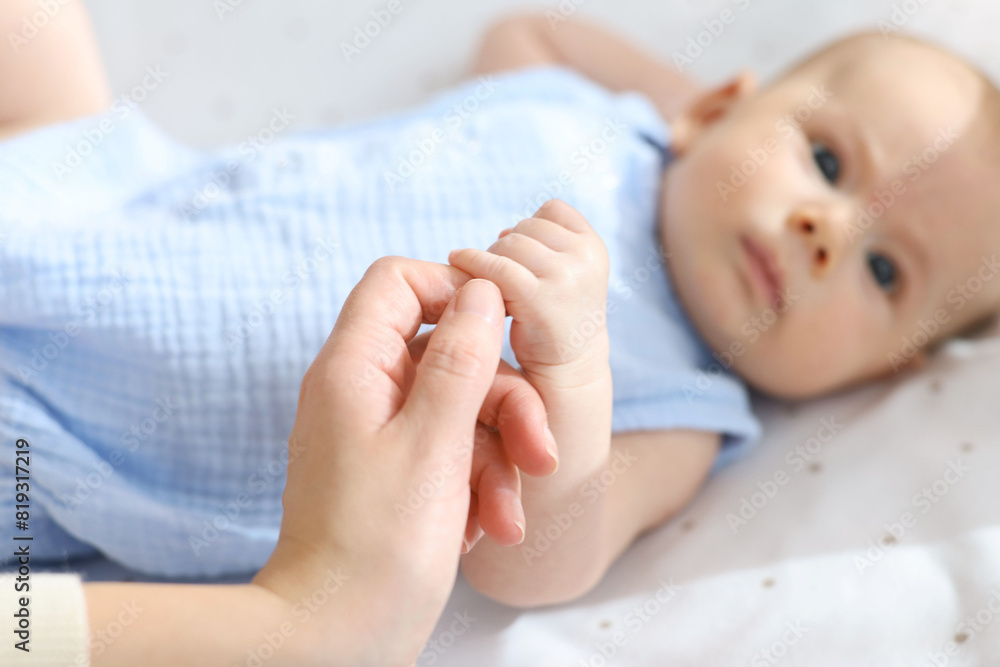 Mother with her cute little baby in crib, selective focus Mother with her cute little baby in crib, selective focus