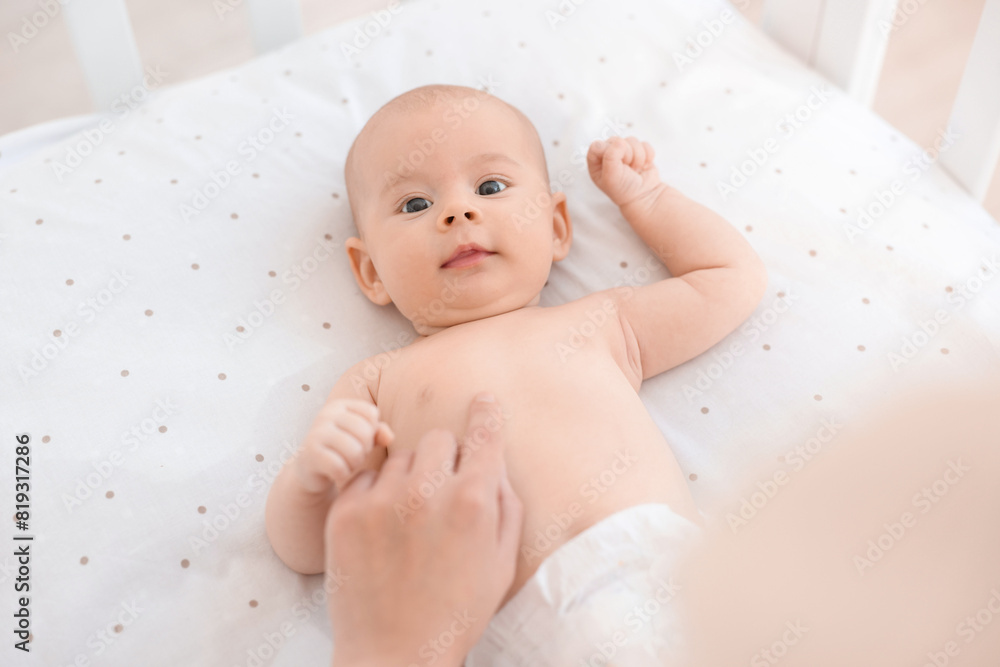 Mother with her cute little baby in crib Mother with her cute little baby in crib