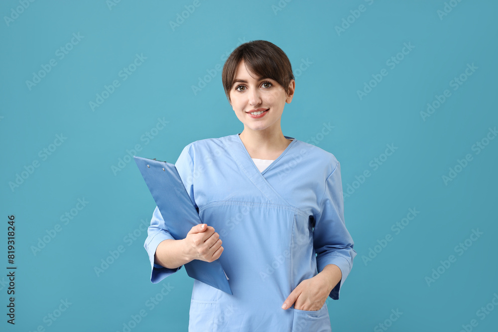 Portrait of smiling medical assistant with clipboard on light blue background Portrait of smiling medical assistant with clipboard on light blue background