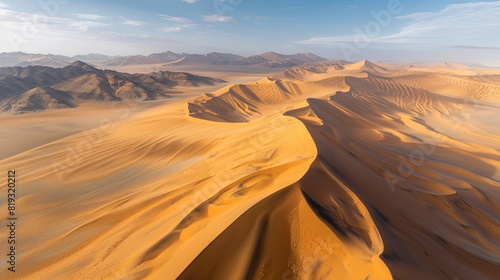 The desert dunes are illuminated by the warm sunlight  which casts long shadows across the landscape