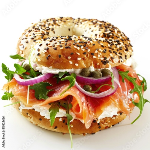 Smoked salmon and cream cheese sandwich with red onion, capers, and arugula on a sesame seed bagel, white background