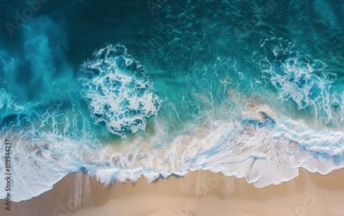 Aerial view of turquoise ocean waves meeting sandy shore. © Mark