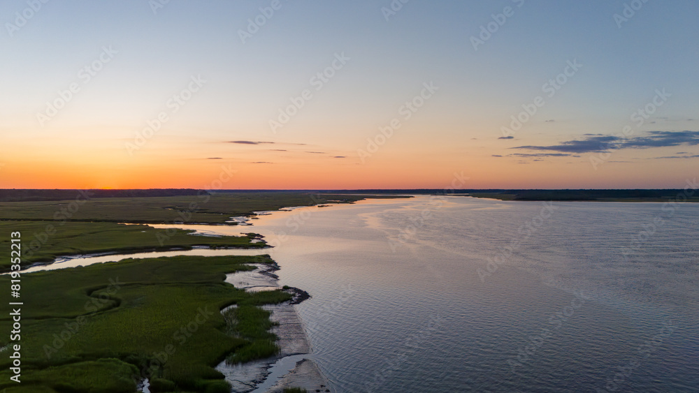 Obraz premium Aerial sunset along river with marsh grasses landscape