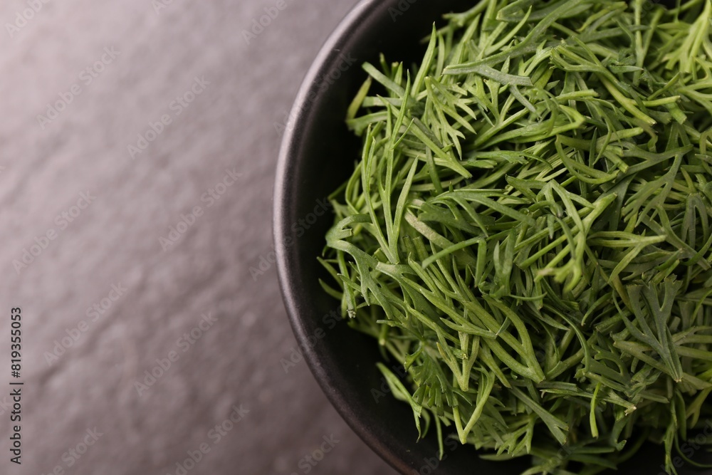 Fresh cut dill in bowl on dark table, top view. Space for text Fresh cut dill in bowl on dark table, top view. Space for text
