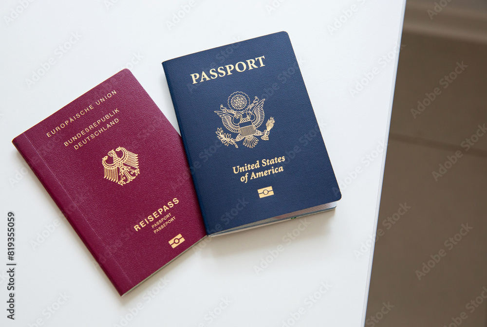 Close up of an American and German passports on white table Close up of an American and German passports on white table