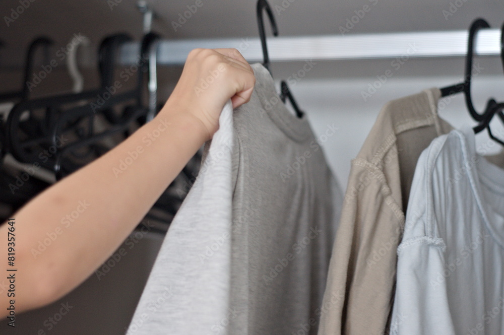 Obraz premium close up hanging T-shirts in the closet. closes