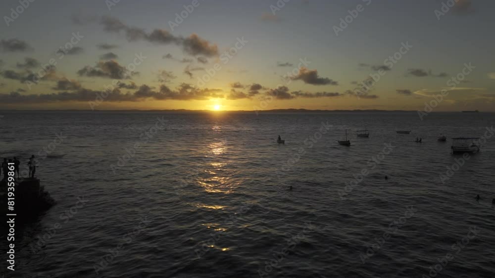 Drone flies to left over water with people on pier at sunset Drone flies to left over water with people on pier at sunset