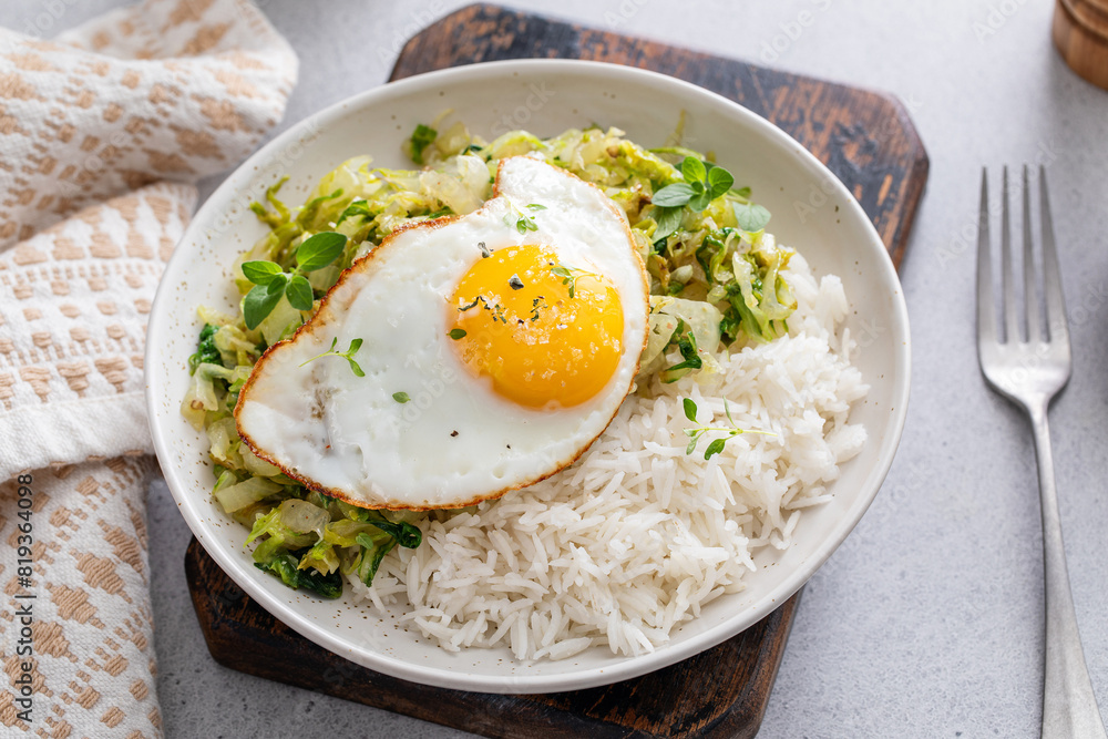 Fresh sauteed leafy greens with rice and topped with fried egg Fresh sauteed leafy greens with rice and topped with fried egg