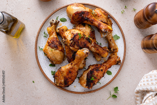 Juicy roasted or grilled chicken drumsticks on plate